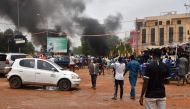 A general view of billowing smoke as supporters of the Nigerien defence and security forces attack the headquarters of the Nigerien Party for Democracy and Socialism (PNDS), the party of overthrown President Mohamed Bazoum, in Niamey on July 27, 2023. (Photo by AFP)
