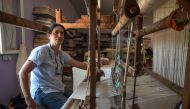 Emel Duman, owner of Appollon Defne silk, poses as she weaves silk fabric in Antakya on July 10, 2023. Photo by Ozan KOSE / AFP