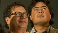 (FILES) Dismissed Bogota's Mayor Gustavo Petro (L) waves to supporters as his son Nicolas Petro looks on from the City Hall balcony during a demonstration in downtown Bogota on January 13, 2014. (Photo by EITAN ABRAMOVICH / AFP)
