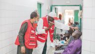 A QRCS volunteer checking the eyes of a patient.