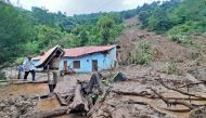 A security personnel carries the belongings of a villager from the site of a landslide after heavy rains at Jadon village in Solan district of India's Himachal Pradesh state on August 14, 2023. Photo by AFP