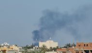 Smoke billows amid clashes between armed groups affiliated with Libya's Tripoli-based Government of National Unity (GNU) in the Libyan capital on August 15, 2023. (Photo by Mahmud TURKIA / AFP)
