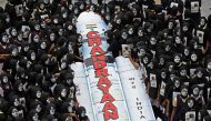 Students with painted faces surround a replica of the Chandrayaan-3 spacecraft in Chennai on August 22, 2023. (Photo by R.Satish Babu / AFP)