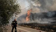A Greek firefighter battles a forest fire spreading in Dikella near Alexandroupoli, northern Greece, on August 23, 2023. Photo by Sakis MITROLIDIS / AFP