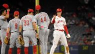 Designated hitter Shohei Ohtani #17 of the Los Angeles Angels is greeted by Cincinnati Reds infielders during a pitching change after Ohtani's double during the fifth of game two of a doubleheader at Angel Stadium of Anaheim on August 23, 2023 in Anaheim, California. Kevork Djansezian/Getty Images/AFP