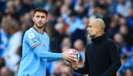 (FILES) Manchester City's Spanish manager Pep Guardiola (R) speaks to Manchester City's French defender Aymeric Laporte during the English Premier League football match between Manchester City and Leicester City at the Etihad Stadium in Manchester, north west England, on April 15, 2023. (Photo by Lindsey Parnaby / AFP)
