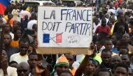 Protesters hold an anti-France placard during a demonstration on independence day in Niamey on August 3, 2023. (Photo by AFP) / ALTERNATE CROP

