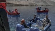 People sit on paddle boats for a ride at the Band e-Amir lake in the Bamiyan Province on October 4, 2021. (Photo by Bulent Kilic / AFP) / XGTY