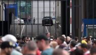 (Files) Police officers (background) secure an area as people and office workers stand in line to enter a building of Expocentre following a drone attack in Moscow on August 18, 2023. (Photo by Natalia Kolesnikova / AFP)