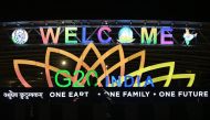 A man rides past an illuminated hoarding with the G20 logo displayed along a street in New Delhi on August 29, 2023. (Photo by Arun Sankar / AFP)

