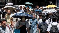 This photo taken on July 30, 2023 shows people using umbrellas and parasols to seek relief from the heat while walking outside Shinjuku station, as temperatures of 35C-plus (95F) have scorched the Japanese capital Tokyo for weeks. Photo by Richard A. Brooks / AFP