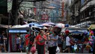 Pedestrians walk as they shop at a market in Manila on January 26, 2022. (Photo by JAM STA ROSA / AFP)

