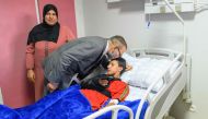 This handout picture taken and released on September 12, 2023 shows Moroccan King Mohammed VI kissing the head of an injured victim at “Mohammed VI” University Hospital in Marrakech, as he pays a hospital visit to victims of the earthquake that rocked the North African country last wee. (Photo by Moroccan Royal Palace / AFP) 