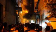 People watch a fire at an apartment building in Hanoi on September 13, 2023. (Photo by AFP)