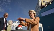 EU Commission President Ursula von der Leyen pushes the button under the eyes of the CEO of A.P. Moller-Maersk, Vincent Clerc (L) during a namegiving ceremony for the world's first methanol-enabled container vessel of A.P. Moller-Maersk in Copenhagen on September 14, 2023. (Photo by Sergei Gapon / AFP)