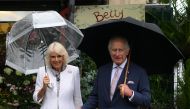 Britain's King Charles III and his wife Queen Camilla pose as they arrive to visit the central Paris Flower Market. (Photo by Daniel Leal / Pool / AFP)