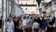 Tourists walk in a street before sunset in Split, Croatia, on September 27, 2023. (Photo by Denis Lovrovic / AFP)