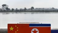 This photo taken on September 22, 2023 shows a general view of the flags of China and North Korea near the Yalu River, on the border between the North Korean town of Sinuiju and the city of Dandong, in China's northeastern Liaoning province.  (Photo by Pedro Pardo / AFP) 
