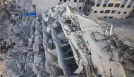 People inspect the ruins of a building destroyed in Israeli strikes in Gaza City on October 8, 2023. (Photo by Mahmud Hams / AFP)
