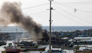 A plume of smoke rises above the port in the Gaza Strip after an Israeli air strike, on October 8, 2023. (Photo by MOHAMMED ABED / AFP)
