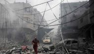 A Palestinian runs amidst the debris after an Israeli airstrike on buildings in the refugee camp of Jabalia in the Gaza Strip on October 9, 2023. Photo by Mohammed ABED / AFP