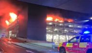 This frame grab from handout video footage taken and released by the Bedfordshire Fire and Rescue Service via AFPTV on October 11, 2023 shows a parking structure on fire at London's Luton Airport. Photo by Handout / various sources / AFP