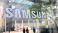 People walk past the Samsung logo displayed on a glass door at the company's Seocho building in Seoul on April 7, 2023. Photo by Jung Yeon-je / AFP

