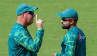 Pakistan's captain Babar Azam (R) talks with team director Mickey Arthur during a practice session on the eve of the 2023 ICC Men's Cricket World Cup one-day international (ODI) match between India and Pakistan at the Narendra Modi Stadium in Ahmedabad on October 13, 2023. (Photo by Punit PARANJPE / AFP)