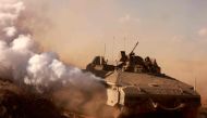 An Israeli armoured personnel carrier drives on a road at an undisclosed location on the border with the Gaza Strip on October 15, 2023. (Photo by Menahem Kahana / AFP)