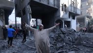 A Palestinian reacts amidst the rubble of a building after an Israeli airstrike on the Rafah refugee camp, in the southern Gaza Strip on October 17, 2023. (Photo by Mohammed Abed / AFP)