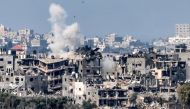 Smoke rises above buildings destroyed by Israeli bombardment in Gaza yesterday. (AFP)