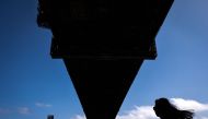 A Chinese tourist takes a photograph with her phone as she walks underneath the Sydney Harbour Bridge on October 25, 2023. Photo by DAVID GRAY / AFP