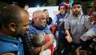 Al-Jazeera correspondent Wael Al-Dahdouh mourns over the body of one of his children in the Nuseirat camp, at Al-Aqsa hospital in Deir Al-Balah on the southern Gaza Strip, on Ocober 25, 2023. (Photo by Majdi FATHI / AFP)