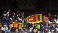 Fans hold Sri Lanka's national flags during the 2023 ICC Men's Cricket World Cup one-day international (ODI) match between England and Sri Lanka at the M. Chinnaswamy Stadium in Bengaluru on October 26, 2023. (Photo by DIBYANGSHU SARKAR / AFP)