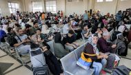 People sit in the waiting area at the Rafah border crossing in the southern Gaza Strip before crossing into Egypt on November 1, 2023. Photo by MOHAMMED ABED / AFP
