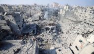 People check the rubble of buildings destroyed in an Israeli strike on the Bureij refugee camp in the central Gaza Strip yesterday. (AFP)