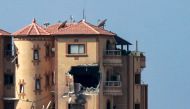 This picture taken on November 3, 2023 shows a gaping hole following a strike on the Hajji building, which houses several offices including those of Agence France Presse (AFP) in Gaza City. (Photo by Bashar TALEB / AFP) 