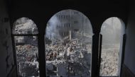 People sift through the smouldering rubble of buildings destroyed in an Israeli strike on the Bureij refugee camp in the central Gaza Strip on November 2, 2023. (Photo by Mahmud Hams / AFP)