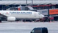 A police van observe the car of a hostage taker seen parked under a Turkish airline plane on the tarmac at the airport in Hamburg, northern Germany on November 5, 2023. Photo by NEWS5 / Schrِder / NEWS5 / AFP