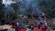 Survivors of a recent earthquake, rest under an open sky near a damaged house, in the early hours of Rukum district on November 5, 2023. Photo by Prakash MATHEMA / AFP