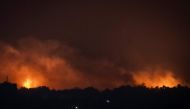 A picture taken from Sderot along the border with the Gaza Strip shows smoke and fire rising over the Palestinian enclave during an Israeli strike on November 5, 2023. (Photo by Aris Messinis / AFP)