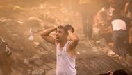 A Palestinian man reacts as others check the rubble of a building in Khan Yunis on November 6, 2023. Photo by MAHMUD HAMS / AFP