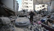 A Palestinian man inspects the damage in Gaza City's Shati refugee camp on November 6, 2023. (Photo by Bashar Taleb / AFP)