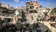 People gather by the rubble of a building that collapsed after Israeli bombardment while searching for survivors and the bodies of victims, in Khan Yunis in the southern Gaza Strip on November 8, 2023. Photo by Mahmud HAMS / AFP