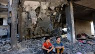 Children sit amid the rubble of a building in the aftermath of an Israeli strike in Rafah in the southern Gaza Strip on November 10, 2023. Photo by Mohammed ABED / AFP