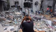 A child reacts as people salvage belongings from a damaged building following strikes on Rafah in the southern Gaza Strip, on November 12, 2023. Photo by Mohammed ABED / AFP