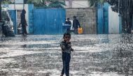 A boy stands in the rain at a school run by the United Nations Relief and Works Agency for Palestine Refugees in the Near East (UNRWA) in Rafah in the southern Gaza Strip on November 14, 2023. Photo by SAID KHATIB / AFP