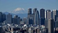 This picture taken on November 14, 2023 shows Japan's highest mountain, Mt. Fuji in the background between skyscrapers in Tokyo's Shinjuku area. (Photo by Kazuhiro NOGI / AFP)