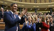 Spain's acting Prime Minister Pedro Sanchez (L) celebrates after winning a parliamentary vote to elect Spain's next premier, at the Congress of Deputies in Madrid on November 16, 2023. (Photo by Javier Soriano / AFP)