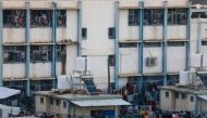 A picture shows hanging laundry belonging to internally displaced Palestinians who have fled the northern Gaza Strip due to intense Israeli military bombardment, in the grounds of a public school where they shelter in Khan Yunis in the southern Gaza Strip on November 16, 2023. Photo by MAHMUD HAMS / AFP